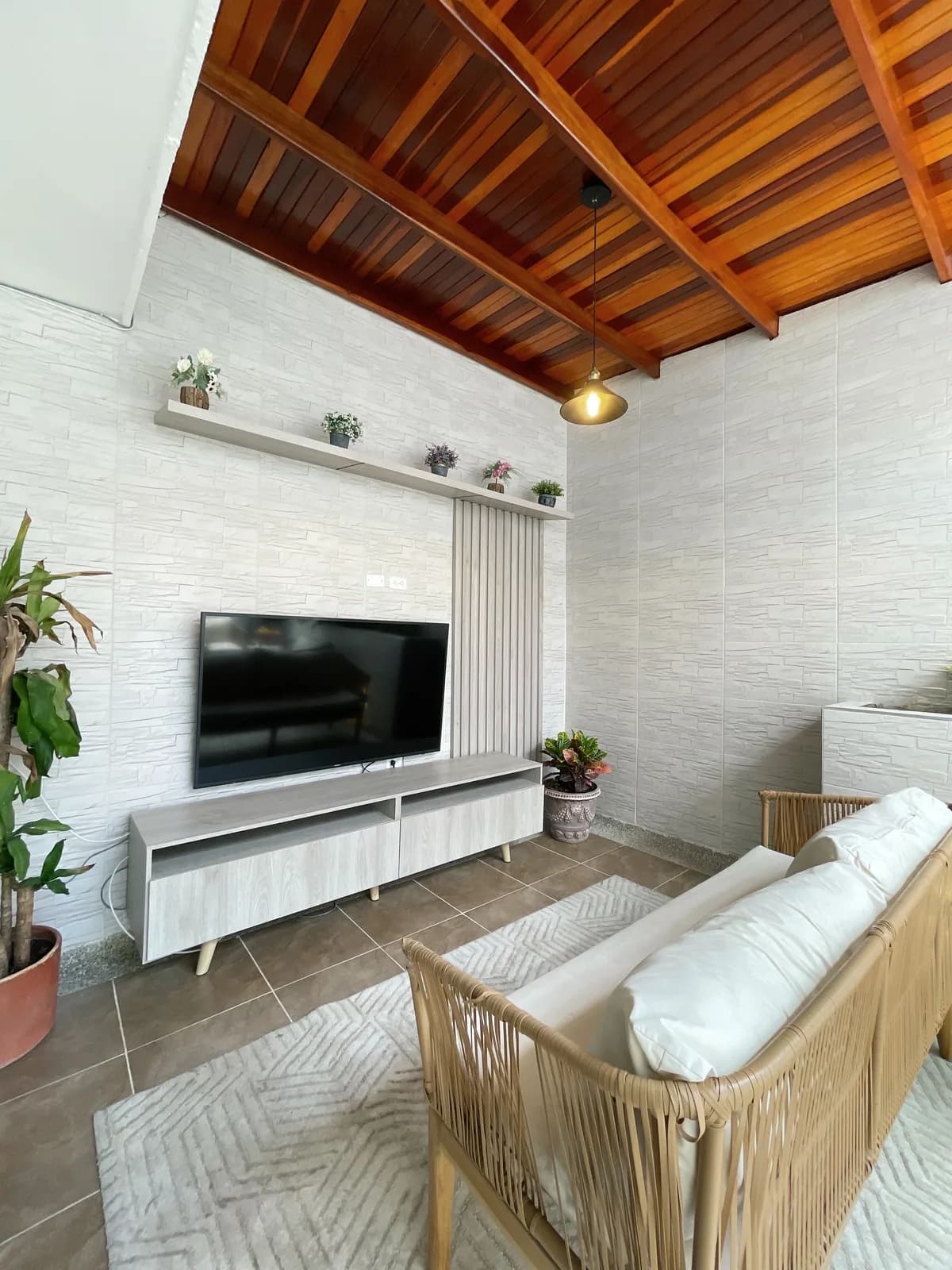 Terraza familiar con cocina exterior, cubierta ventilada y materiales tropicales.